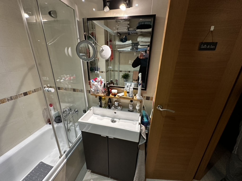 Lavabo, espejo y acceso al baño antes de reformarlo